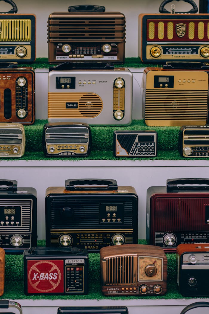A collection of vintage radios displayed on green-lined shelves. Perfect for retro enthusiasts.